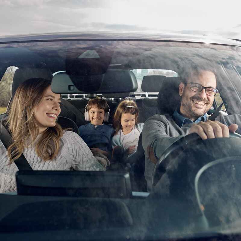 A cheerful family inside a car enjoying their ride together in Burnaby, BC.