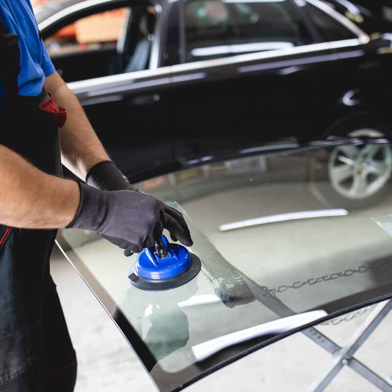 A man works on windshields, showcasing Excellence Auto Glass's repair expertise in Burnaby, BC.